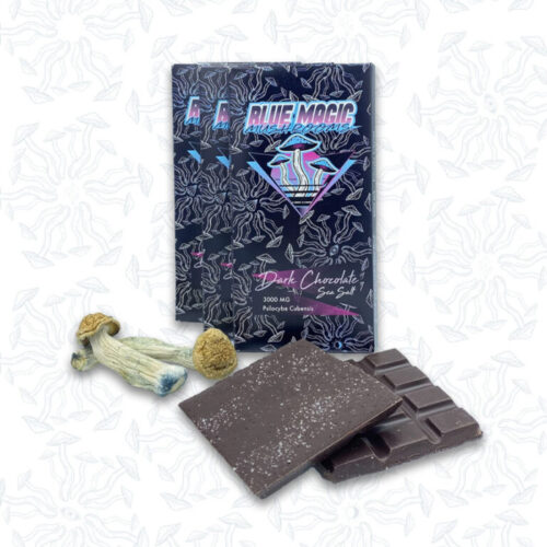 A piece of chocolate bar and two magic mushrooms in front of three chocolate bar packages